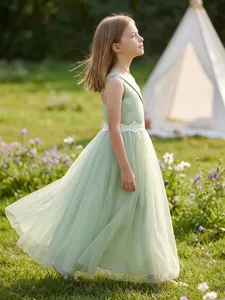 Side view of girl's sage green formal tulle dress presented in an outdoor meadow setting
