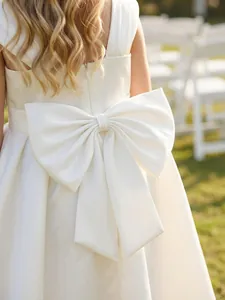 Dettaglio dell'elegante grande fiocco bianco sul retro di un abito da damigella.