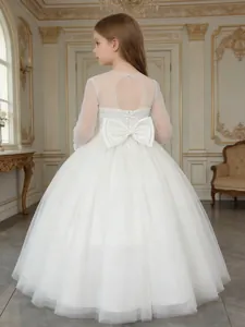 Detailed back view of a white flower girl dress with a large bow and mesh sleeves