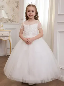 Full view of white lace embroidered flower girl dress with fluffy tulle skirt