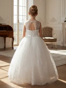 Elegante detalle de un vestido de niña en encaje y tul blanco con la espalda abierta.