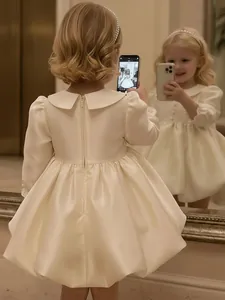 Elegant cream satin flower girl dress with puff sleeves and Peter Pan collar design