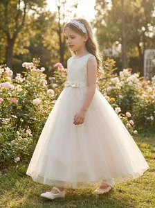Elegant ivory tulle flower girl dress with lace bodice and bow decoration for weddings.