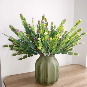 Close-up of artificial cactus plant with small colorful flowers in a green vase