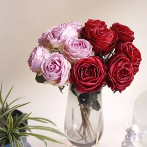 Realistische rosa und rote Rosen mit gebrannten Rändern in einer eleganten Glasvase.