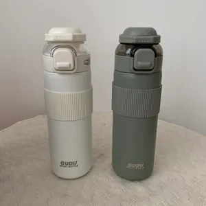 Detail view of two large capacity sports bottles in white and olive green finishes.