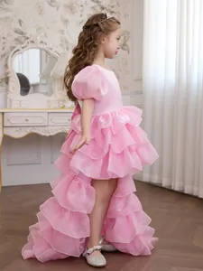 Side view of pink tiered ruffle princess dress with trailing hem and puff sleeves
