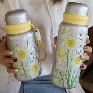 Close-up of 3D floral printed stainless steel thermos bottles with yellow lids and straps