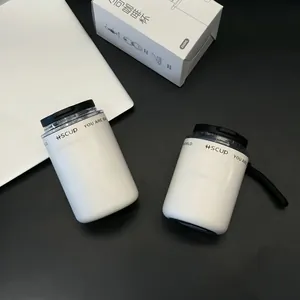 Close-up of matte white stainless steel coffee cups with portable strap and packaging box
