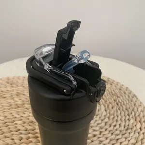 Detail view of the black insulated sports water bottle lid with a blue silicone straw.