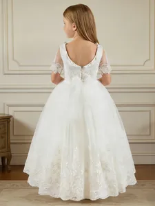 Detailed back view of white lace flower girl dress with elegant bow and floral embroidery