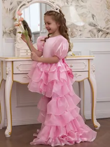 Side view showing the elegant ruffled tiered skirt and long train of the pink girl's dress
