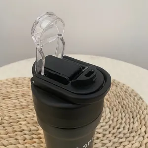 Detail view of the flip-top lid and drinking spout of a black insulated sport bottle