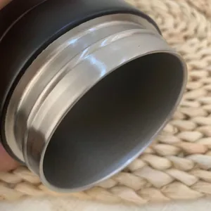 Macro close-up view of the smooth stainless steel rim of an insulated water bottle