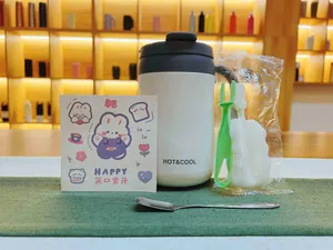Insulated white stainless steel mug with handle featuring HOT and COOL text and cleaning brush set