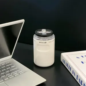 Modern white 304 stainless steel insulated coffee cup on a desk next to laptop.