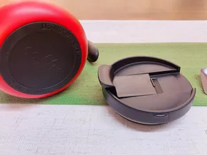 Detail view showing the bottom of a red stainless steel coffee mug and black lid