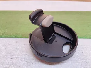 Detailed close-up of a black matte flip-top lid for a stainless steel insulated coffee mug.