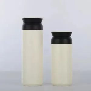 Détail de deux bouteilles isothermes minimalistes en acier inoxydable de couleur crème.