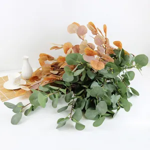 Detalle de hojas de eucalipto artificiales en verde y naranja para decoración de hogar