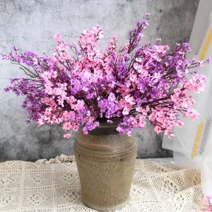 Vista detallada de flores de paniculata artificiales rosas y moradas en un jarrón