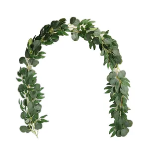 Detail view of artificial eucalyptus and willow leaf garland in green on white backdrop.