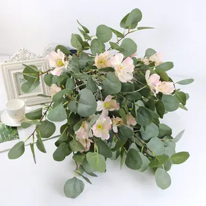 Primer plano de hojas de eucalipto artificiales con delicadas flores rosas decoración
