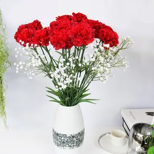 Arreglo de claveles artificiales rojos y paniculata en un elegante jarrón de cerámica blanca.