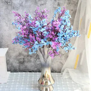 Vista detallada de flores de paniculata de seda violeta y azul en un elegante jarrón.