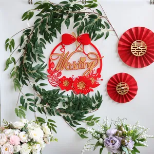 Vue détaillée de liane de saule artificielle et décors en papier rouge pour mariage