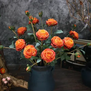 Detailed macro view of burnt edge orange silk roses featuring realistic floral textures