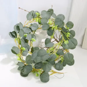 Close-up detail of lifelike silver dollar eucalyptus vine with tiny green-white flower buds.