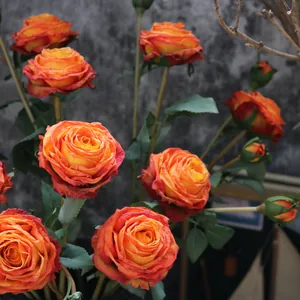 Close-up of artificial burnt-edge silk roses with vibrant orange-red and yellow petals