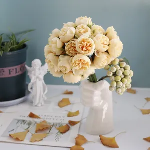 Detail of a 27-head cream tea rose bouquet in a creative hand-shaped ceramic vase.