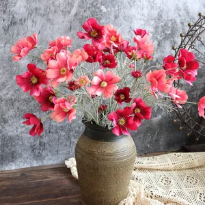Fiori di cosmo artificiali rosa vivace e cipria in un vaso di terracotta marrone rustico