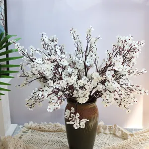 Vista detallada de flores blancas de paniculata artificial en un jarrón de cerámica
