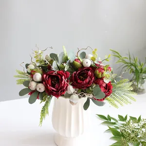 Detailed view of dark red artificial peony bouquet in a white ribbed ceramic vase