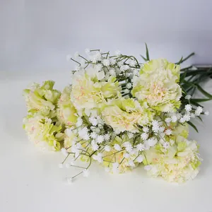 Primer plano de claveles amarillos artificiales mezclados con paniculata blanca.