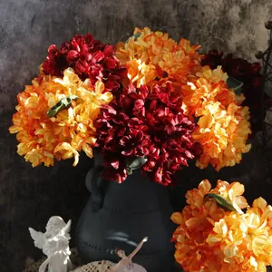 Detailed view of vintage artificial hydrangeas in rich red and orange for home decor