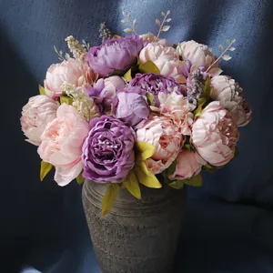 Nahaufnahme eines künstlichen Pfingstrosenstraußes in Rosa und Lila in einer Vase.