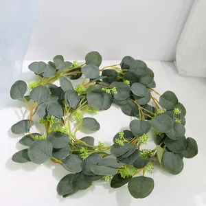 Detailed view of artificial eucalyptus vine with frosted green leaves and white buds.