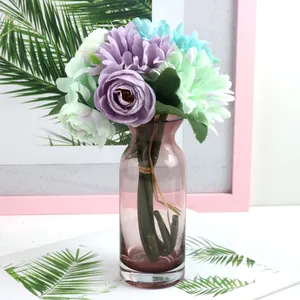 Elegant artificial flower bouquet with roses and gerberas in a pinkish glass vase