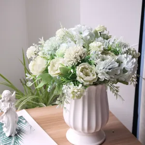 Detailweergave van witte en groene kunstmatige pioenen en hortensia's in keramische vaas
