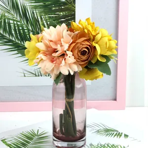 Warm yellow and peach artificial flower bouquet in a pink glass vase for home decor