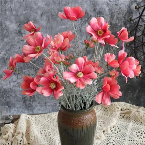 Vivaci fiori di cosmo artificiali in seta rosa in un vaso rustico di ceramica per casa