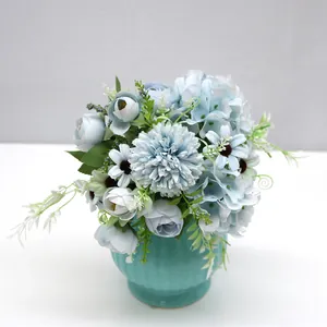 Elegant light blue artificial flower arrangement in a teal ceramic vase for home decor.