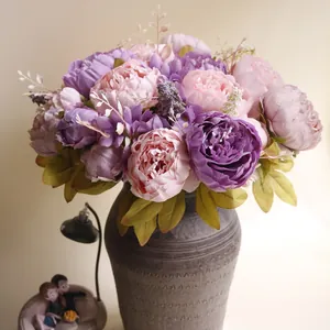 Detailansicht von 13 künstlichen Pfingstrosen in Violett und Rosa in einer grauen Vase.
