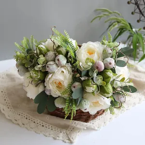 Elegant artificial white peonies and berries in a woven basket on a lace tablecloth