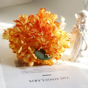 Detailed view of vintage French burnt edge orange artificial hydrangea flowers.