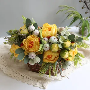 Close-up detail of artificial yellow peony bouquet in a woven basket with eucalyptus